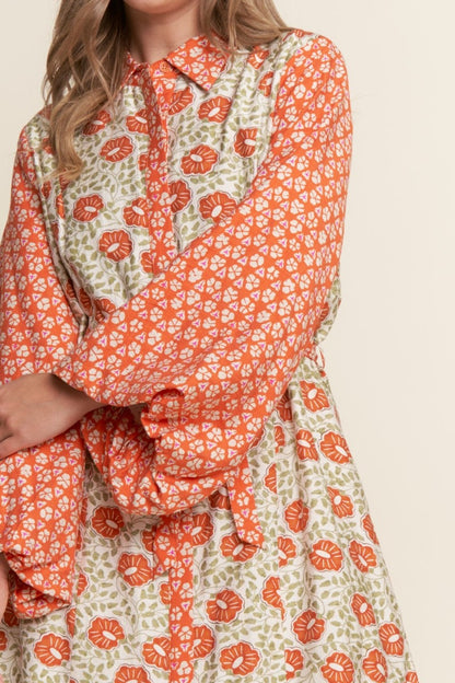 Orange and green floral patterned dress on a beige background
