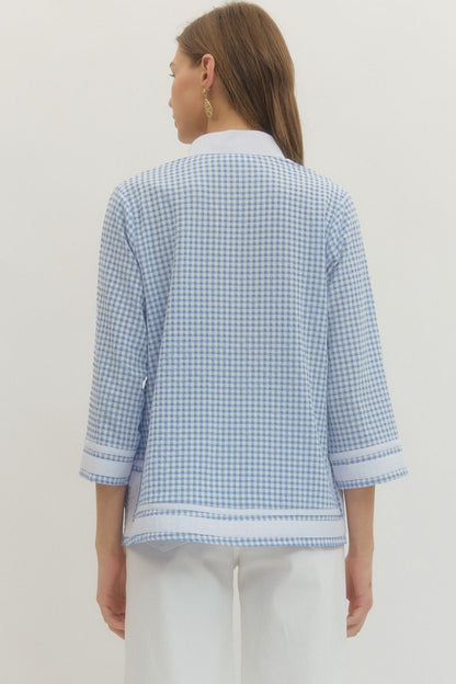 Woman wearing a light blue checkered shirt against a white background