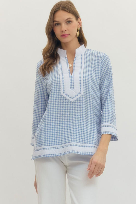 Woman wearing a blue and white checkered blouse with a plain background