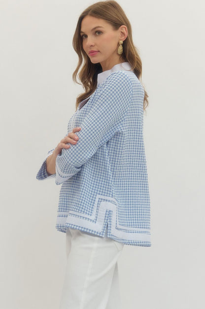 Woman wearing a blue and white checkered jacket on a plain background