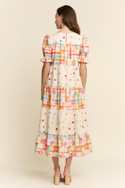 Woman wearing a colorful plaid dress against a beige background