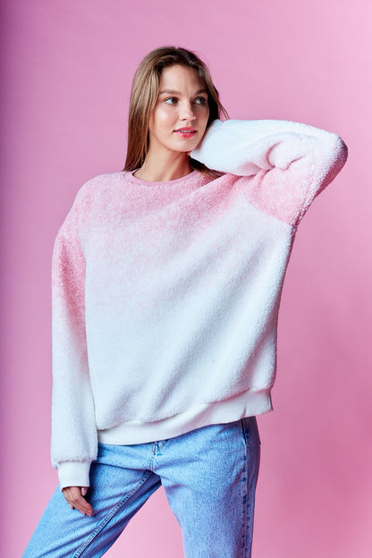 Woman wearing pink and white ombre sherpa sweatshirt with relaxed fit