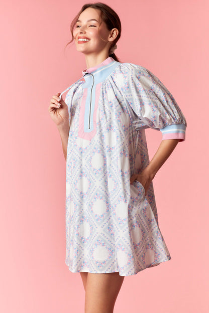 Woman wearing a patterned dress with a pink background