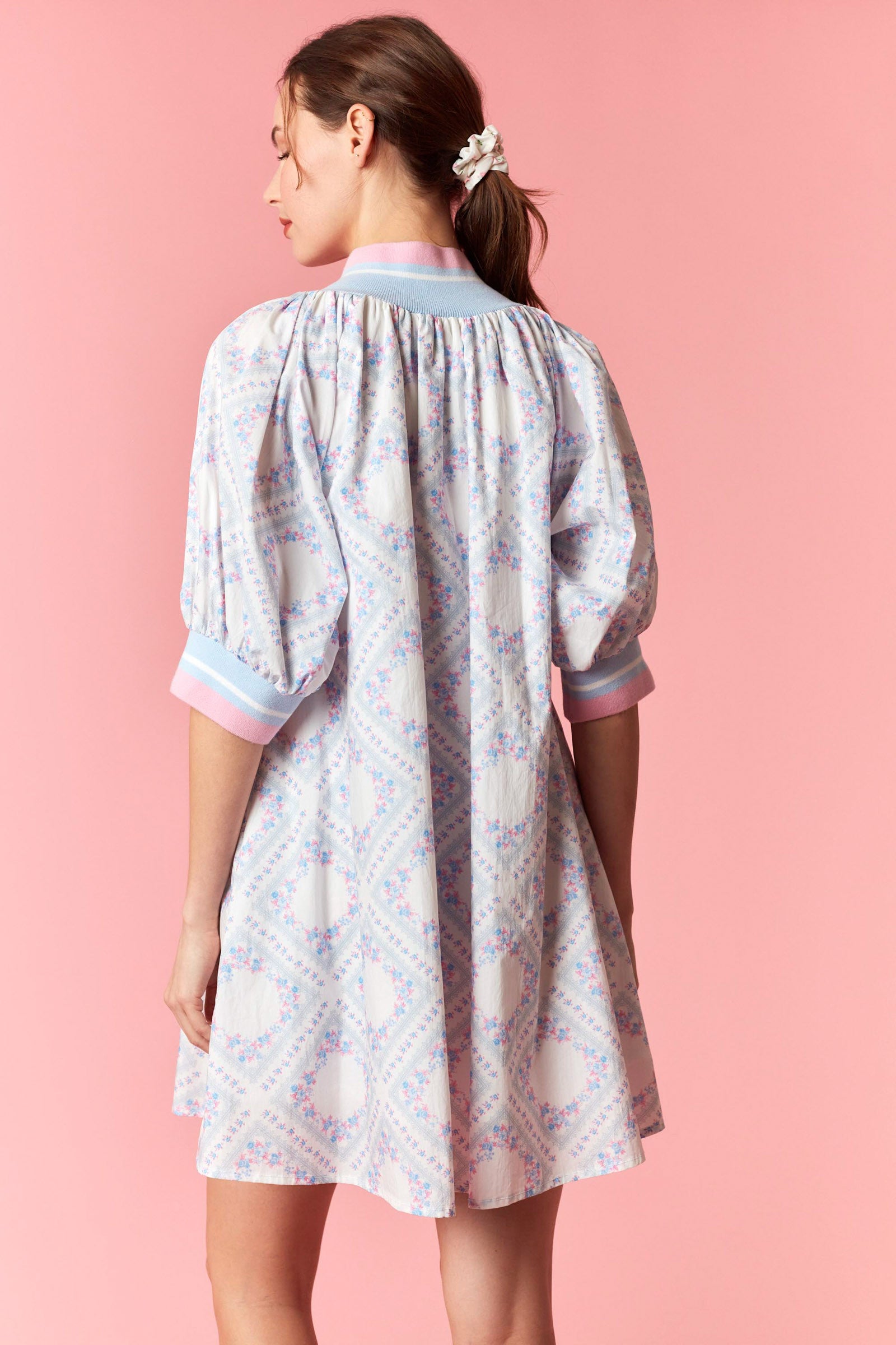 Woman wearing a floral dress with a pink background