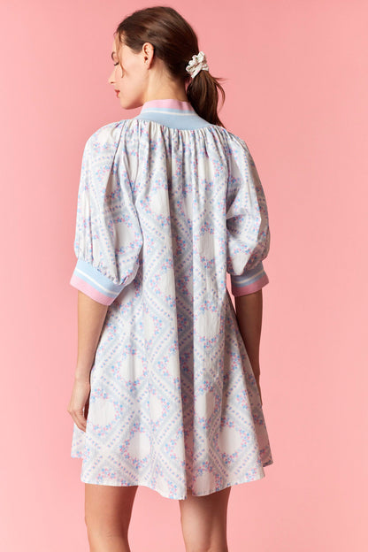 Woman wearing a floral dress with a pink background