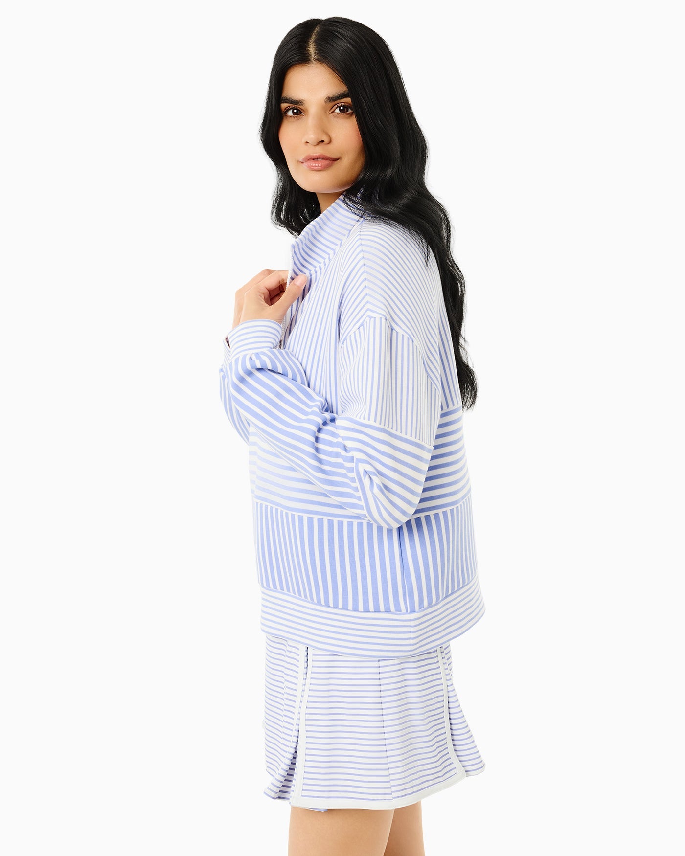 Woman wearing a blue and white striped shirt and skirt on a white background