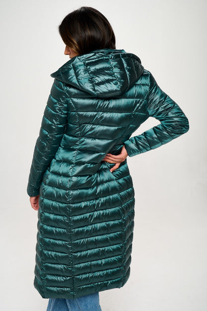 Person wearing a long green puffer coat on a white background