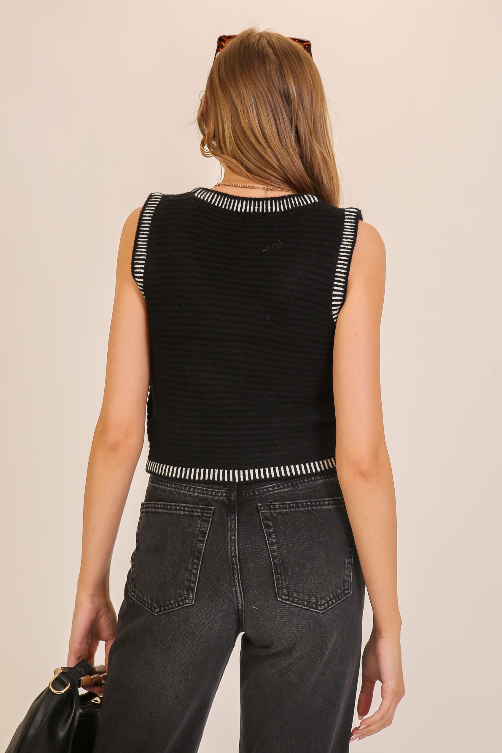 Back view of black and white contrast-trim knit tank with ribbed texture and cropped fit.