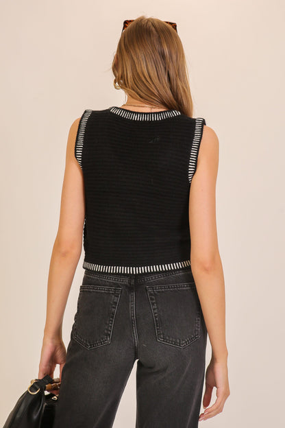 Back view of black and white contrast-trim knit tank with ribbed texture and cropped fit.