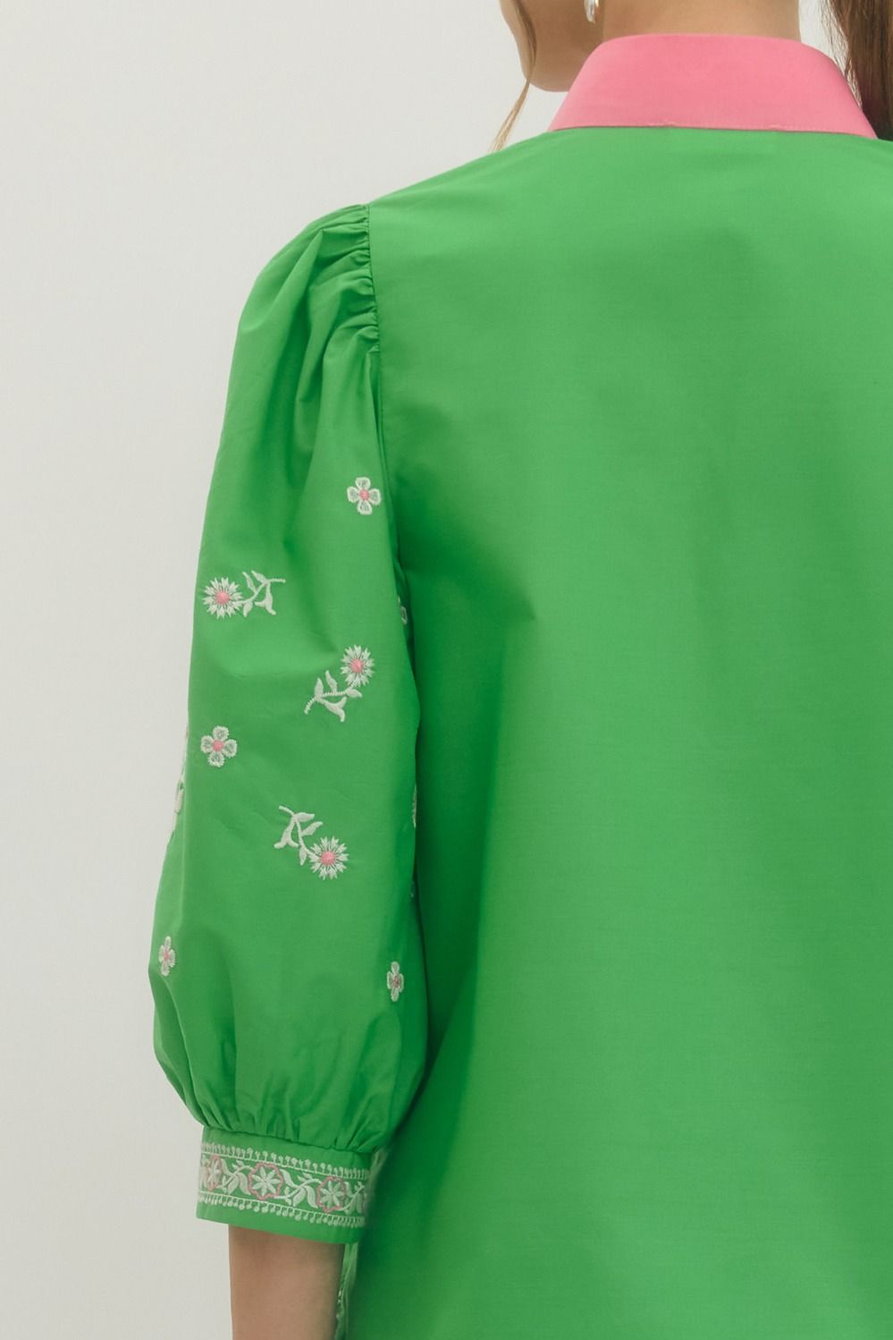 Green jacket with floral embroidery on a plain background