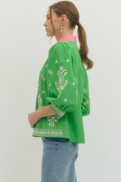Person wearing a green embroidered jacket on a white background