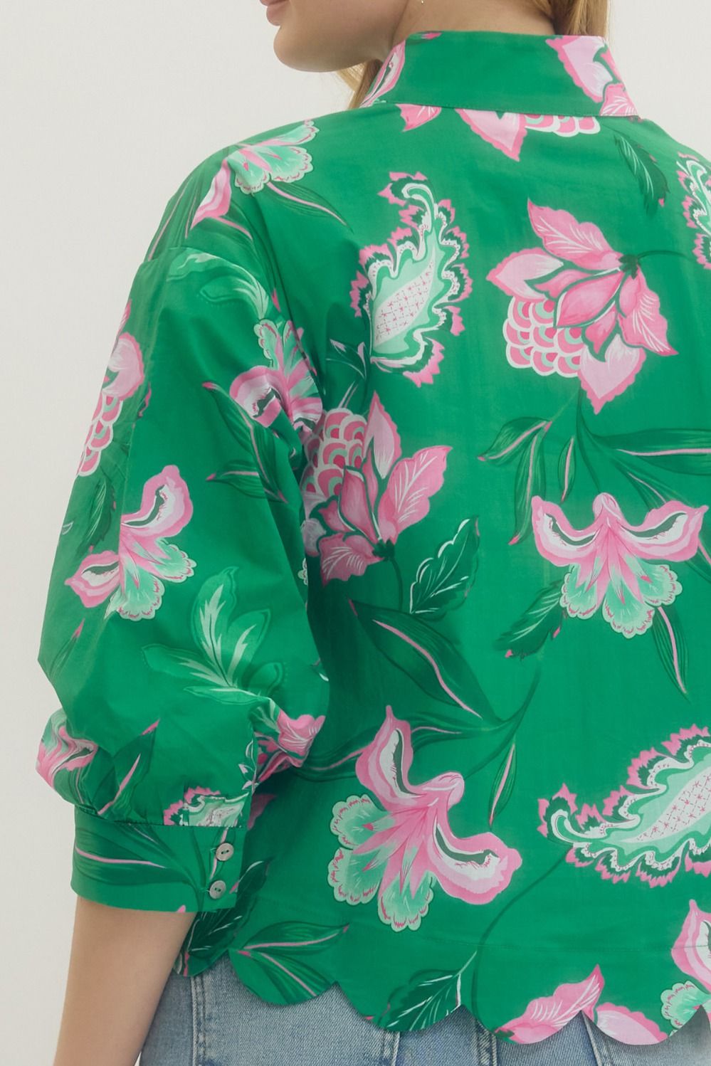 Green floral patterned shirt worn by a person on a white background