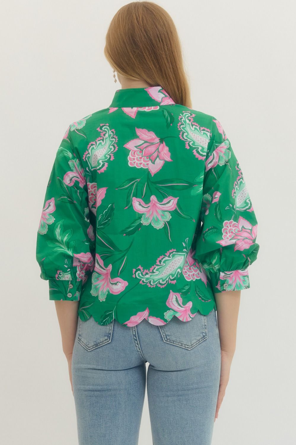 Person wearing a green floral patterned shirt on a white background