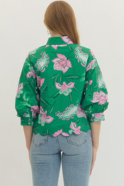 Person wearing a green floral patterned shirt on a white background