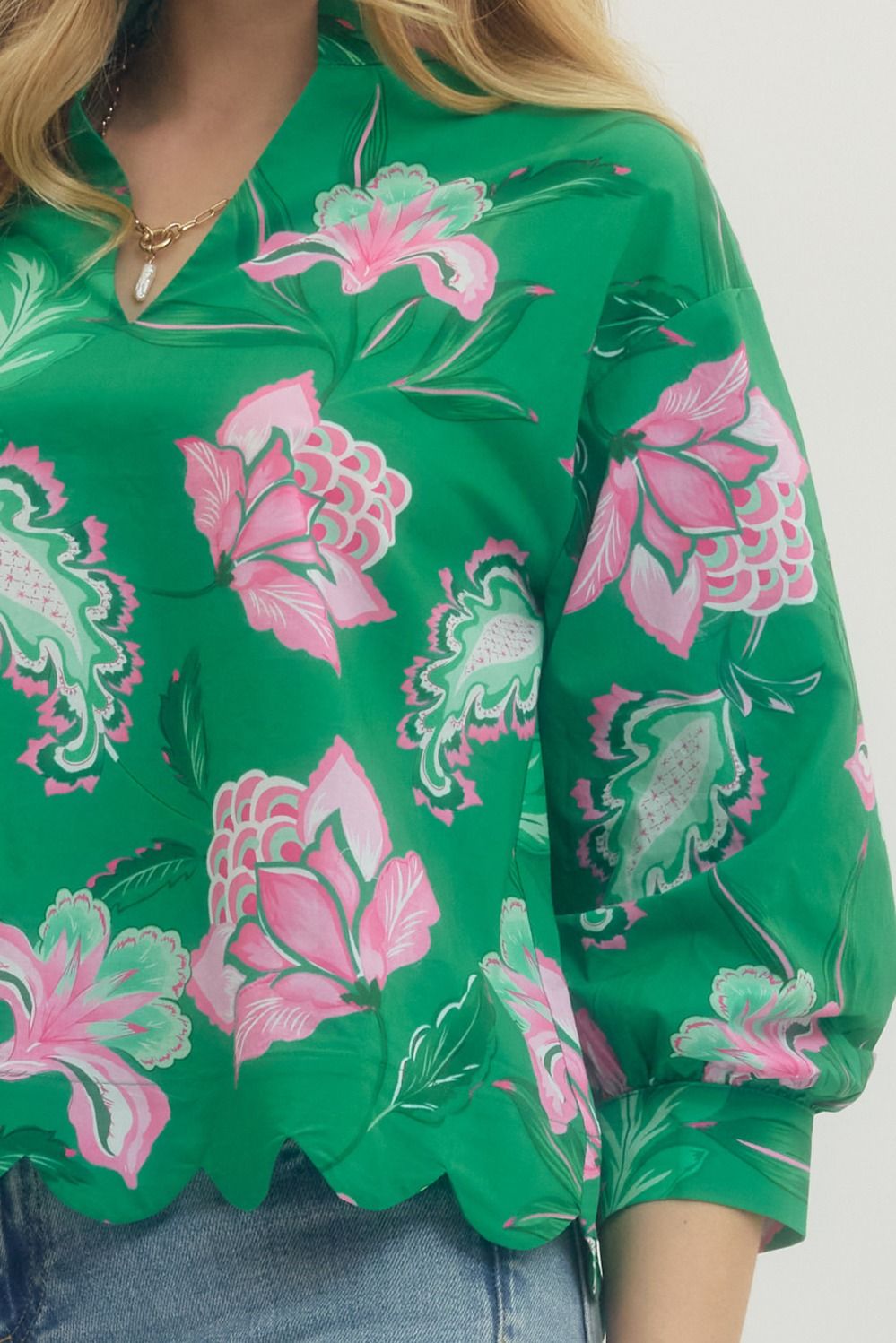 Green blouse with pink floral patterns on a white background