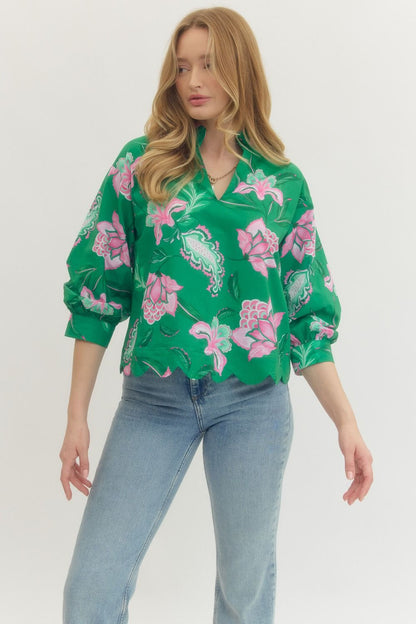 Woman wearing a green floral blouse and blue jeans on a white background