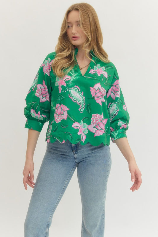 Woman wearing a green floral blouse and blue jeans on a white background