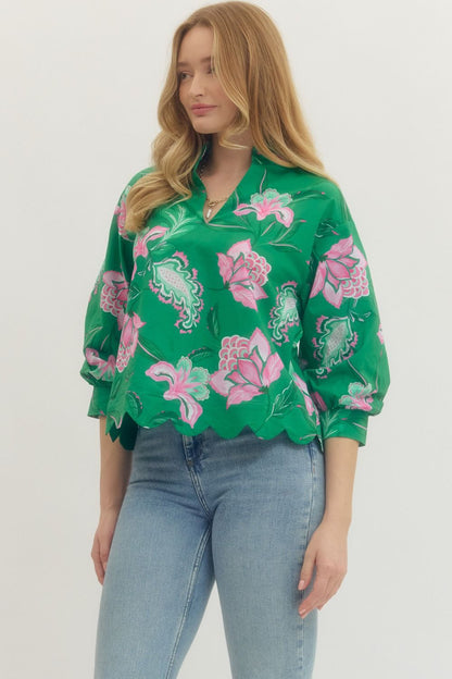 Woman wearing a green floral blouse with pink flowers on a white background