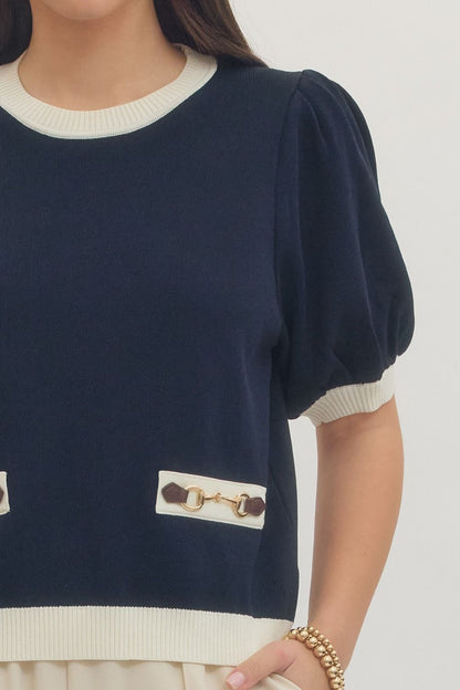 Navy sweater with a decorative button on a plain background