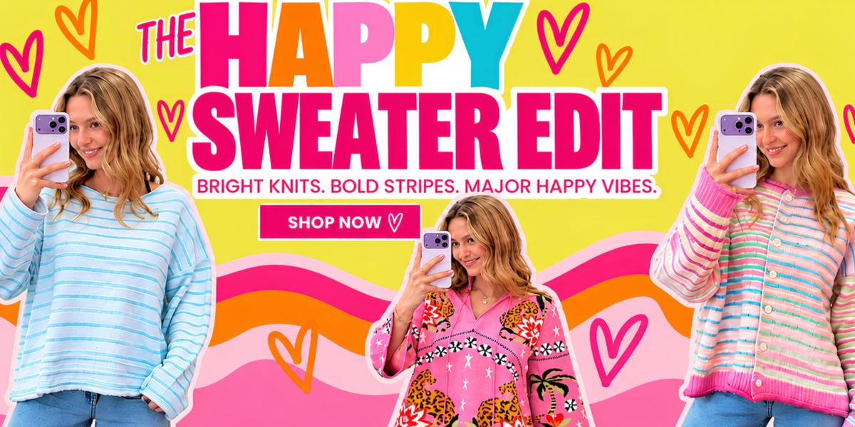 Promotional banner for 'The Happy Sweater Edit' featuring three women modeling colorful knit sweaters against a bright yellow background with pink and orange wavy lines and heart graphics. The text reads 'THE HAPPY SWEATER EDIT' and 'SHOP NOW'.