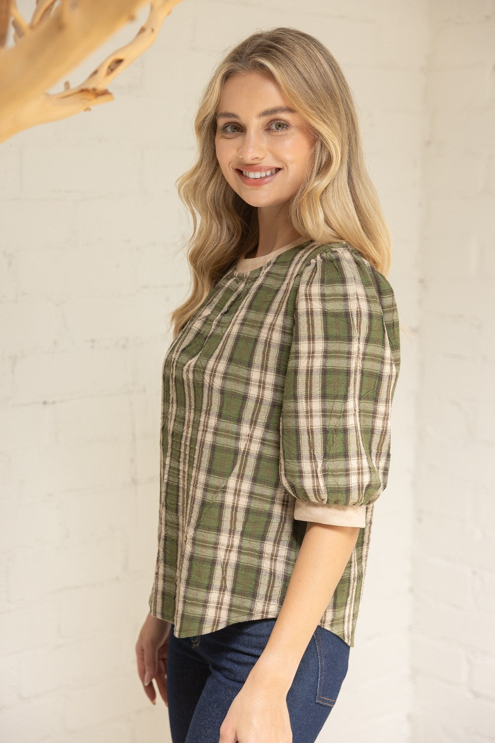 Side view of plaid top featuring puff sleeves and gathered neckline.