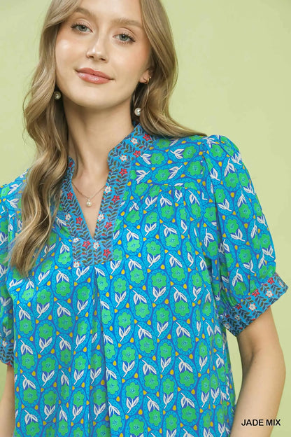 Woman wearing a blue and green patterned shirt against a light green background