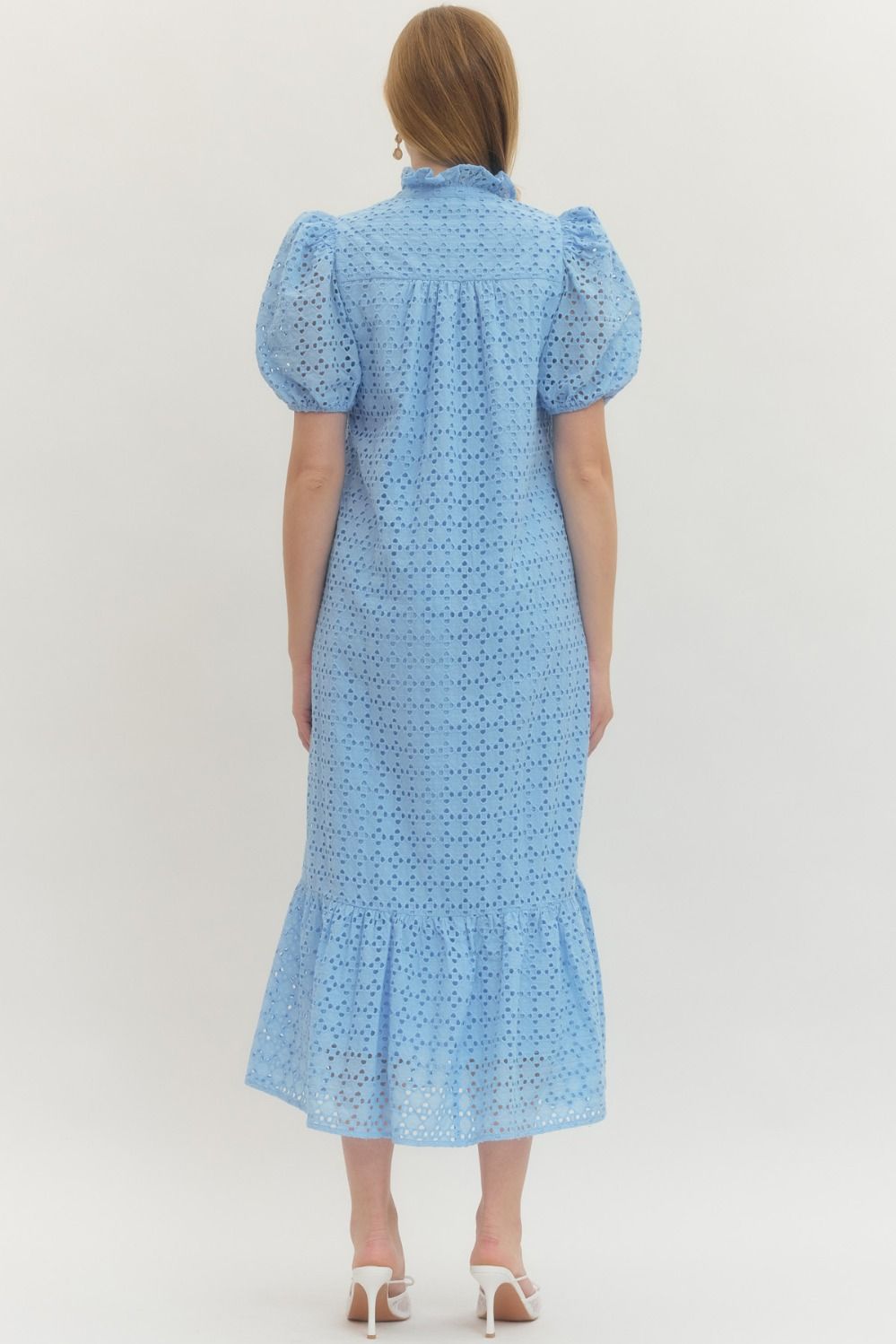 Woman wearing a blue dress with puff sleeves on a white background