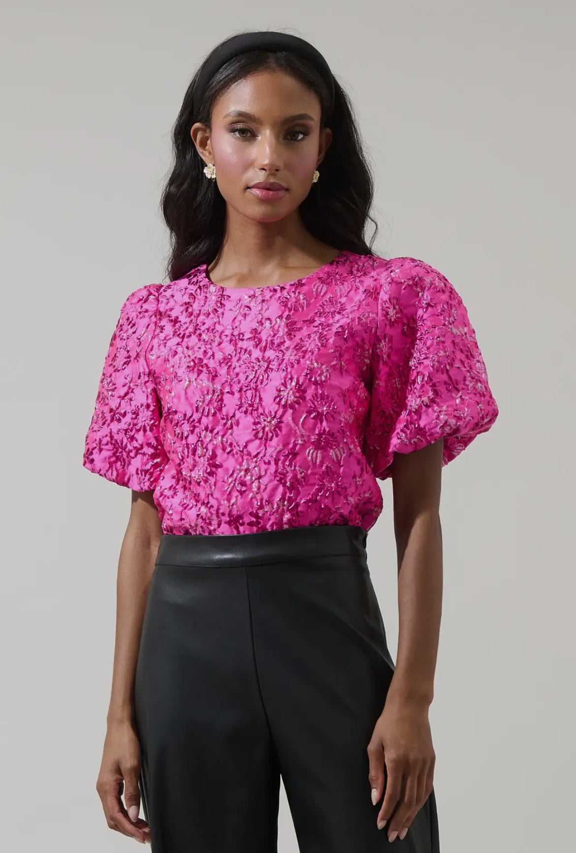 Close-up of hot pink metallic floral embroidery detailing on puff sleeve blouse — luxe boutique statement top.