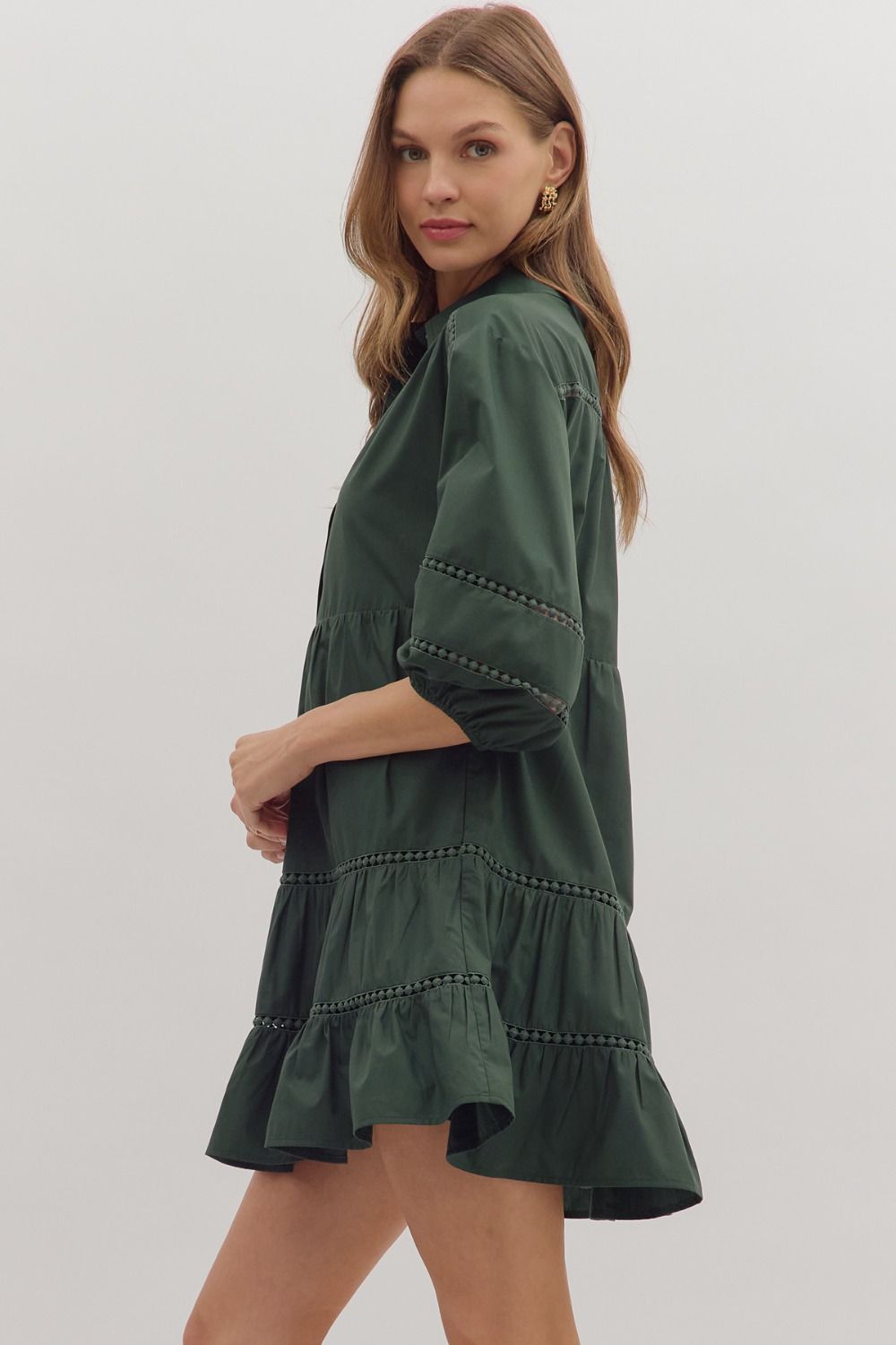 Side view of green A-line mini dress with ruffle hem and lace trim details
