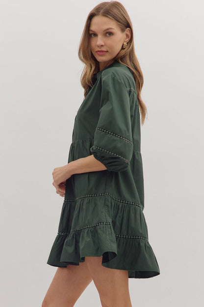 Side view of green A-line mini dress with ruffle hem and lace trim details
