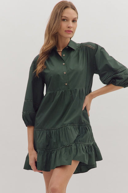 Front view of forest green tiered dress with button neckline and puff sleeves