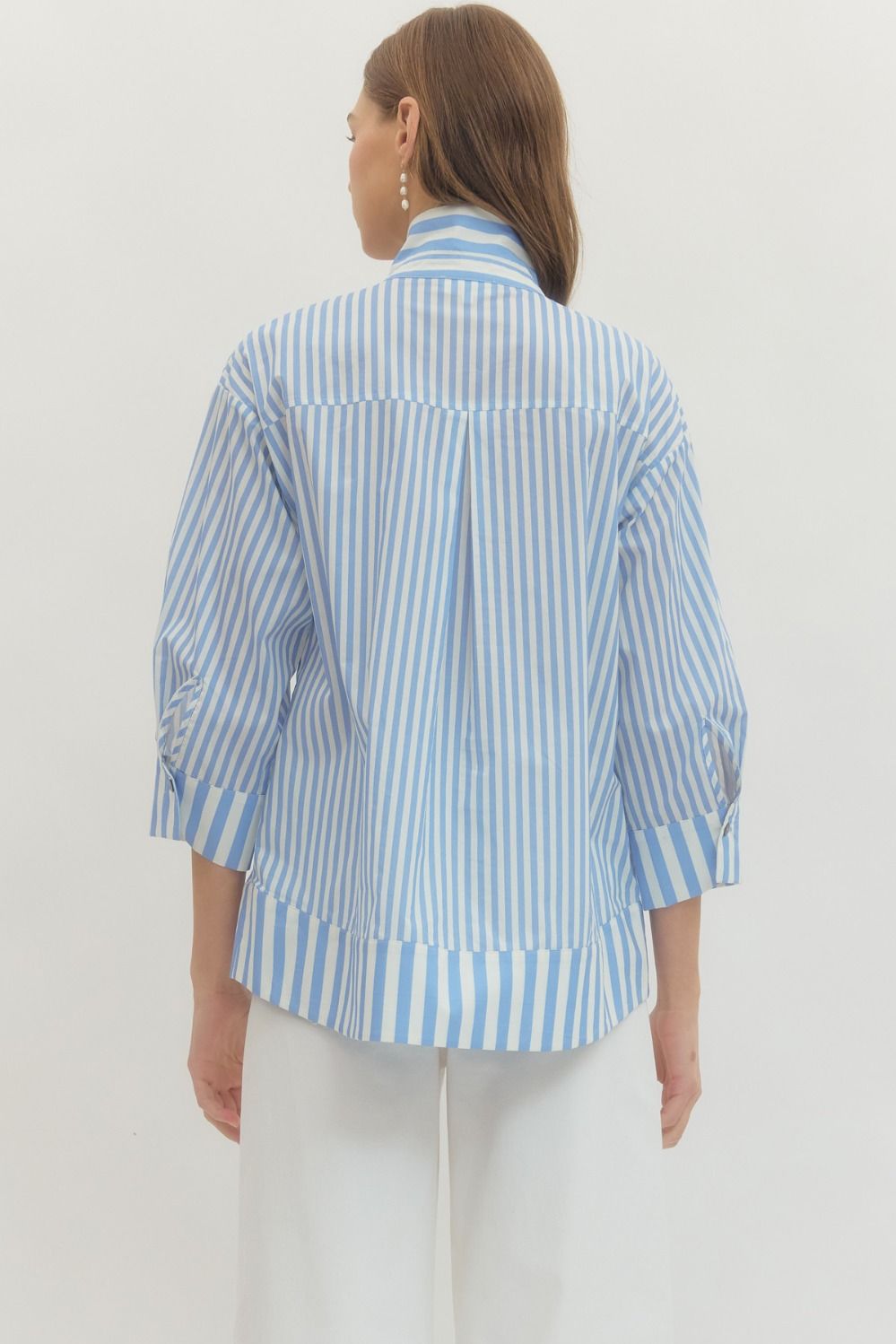Woman wearing a blue and white striped shirt against a plain background