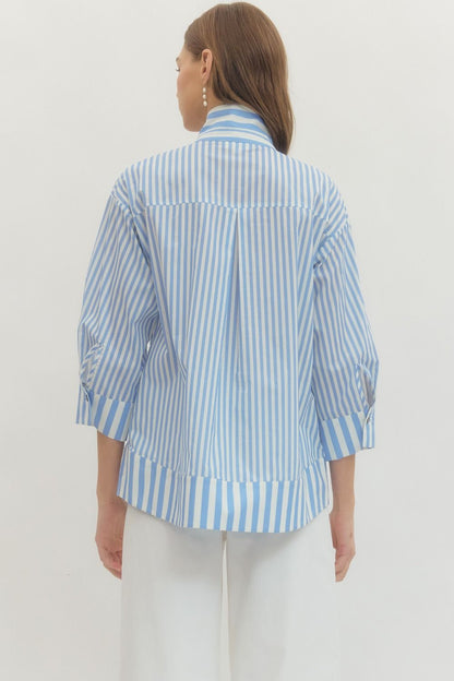 Woman wearing a blue and white striped shirt against a plain background