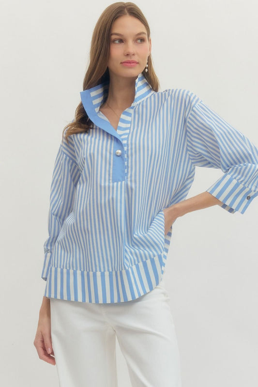 Woman wearing a blue and white striped shirt with a plain background