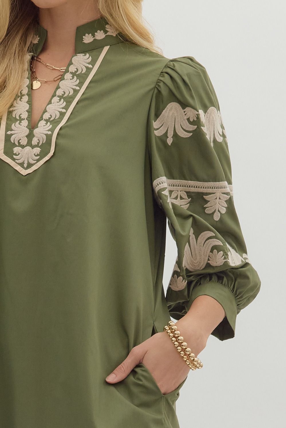Close-up of cream embroidered detailing on olive green puff sleeve dress — stylish fall fashion from Milo & Lily Boutique.