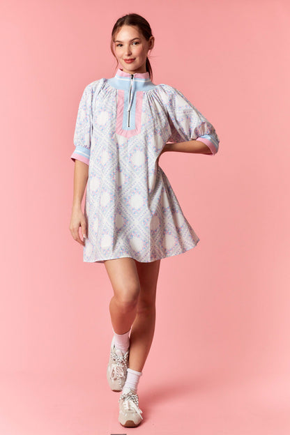 Woman wearing a white dress with pink accents on a pink background