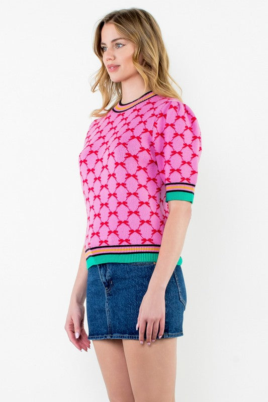 Side view of pink geometric short sleeve knit top with puff sleeves and colorblock trim — fun and bold Milo & Lily piece.
