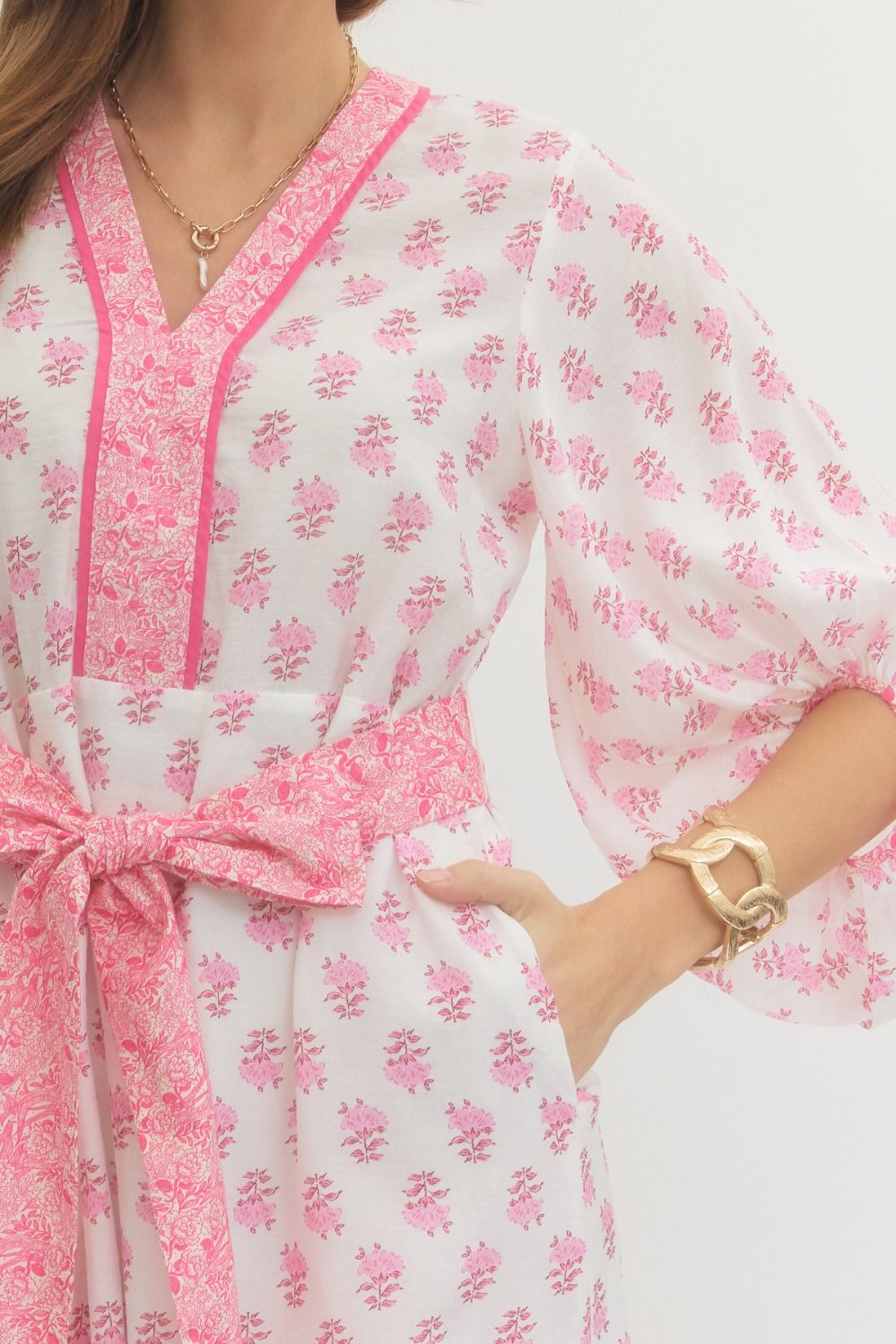 Close-up of a pink and white floral dress with a person wearing it.