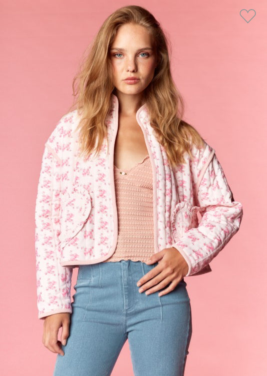 Model wearing a pink quilted floral jacket with heart-shaped pockets and cropped fit — Milo & Lily Boutique feminine outerwear.