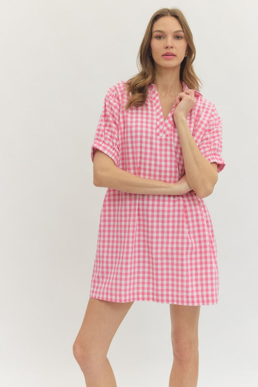 Woman wearing a pink gingham dress on a white background