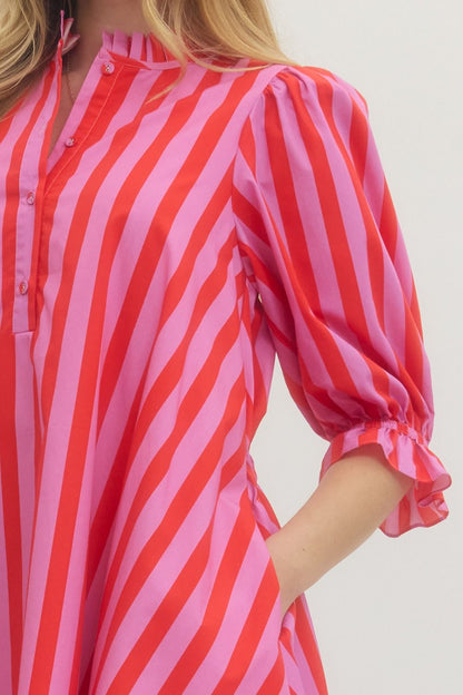 Red and pink striped shirt worn by a person on a white background