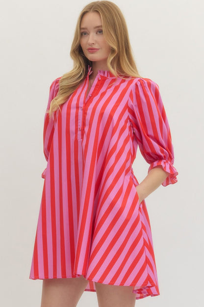 Woman wearing a red and pink striped dress on a white background