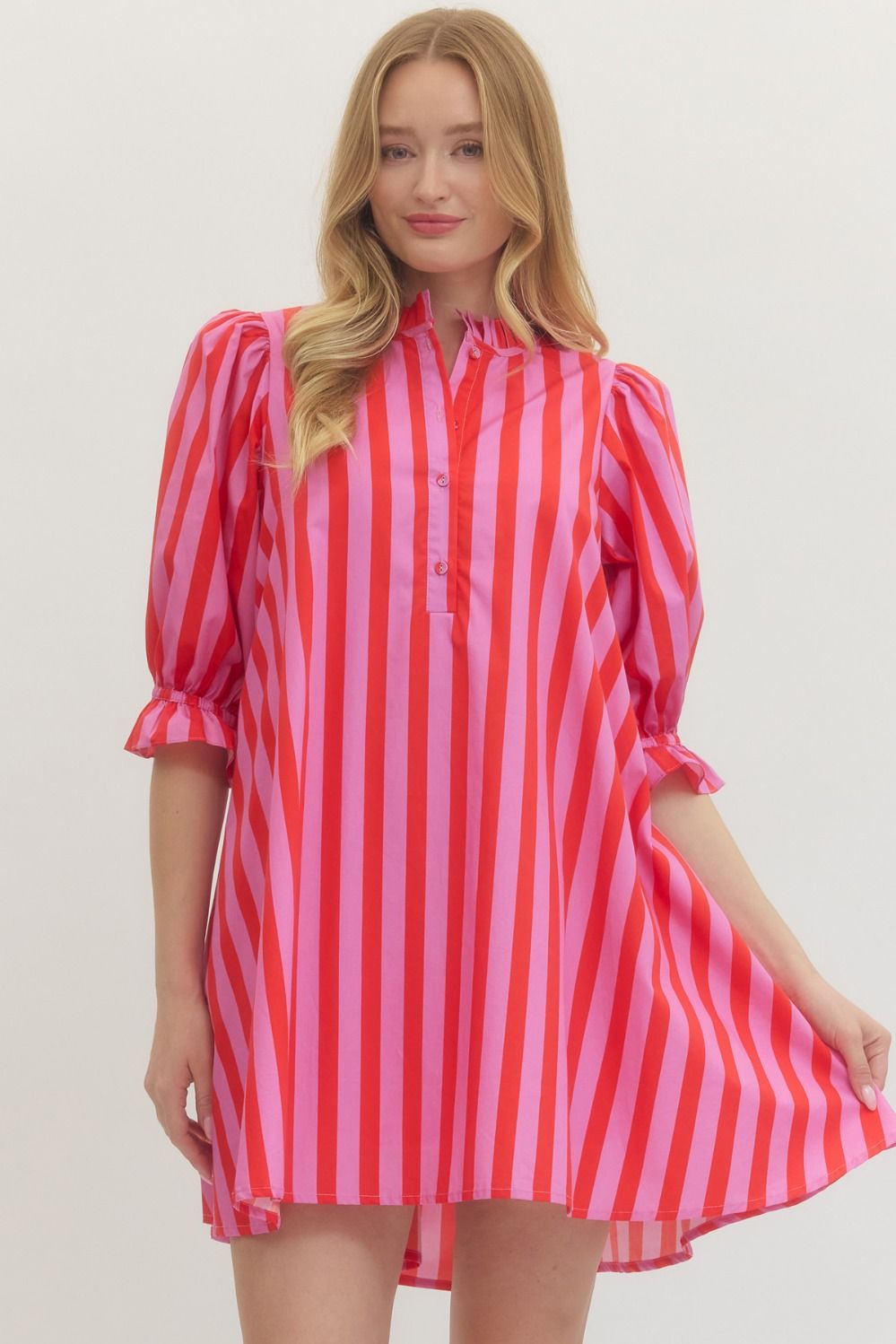 Woman wearing a red and pink striped dress on a white background