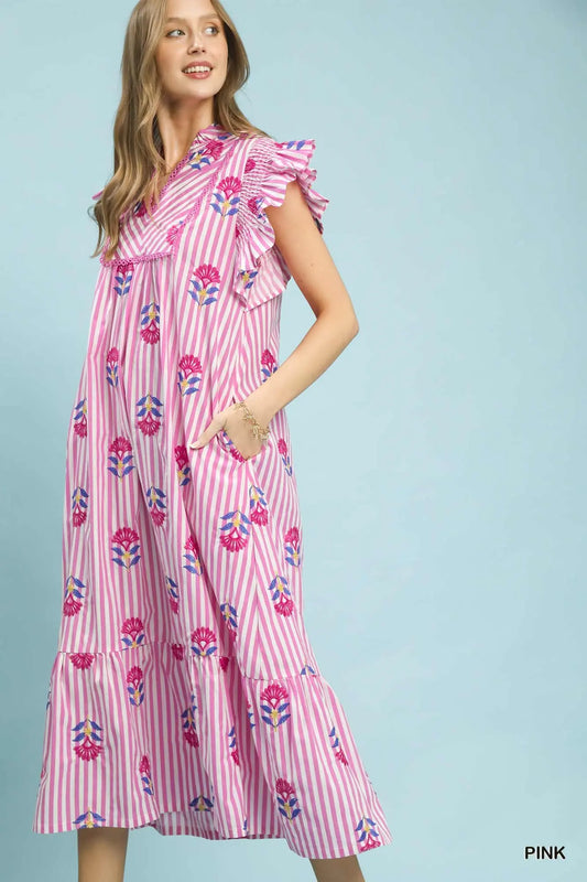 Woman wearing a pink dress with floral pattern on a light blue background