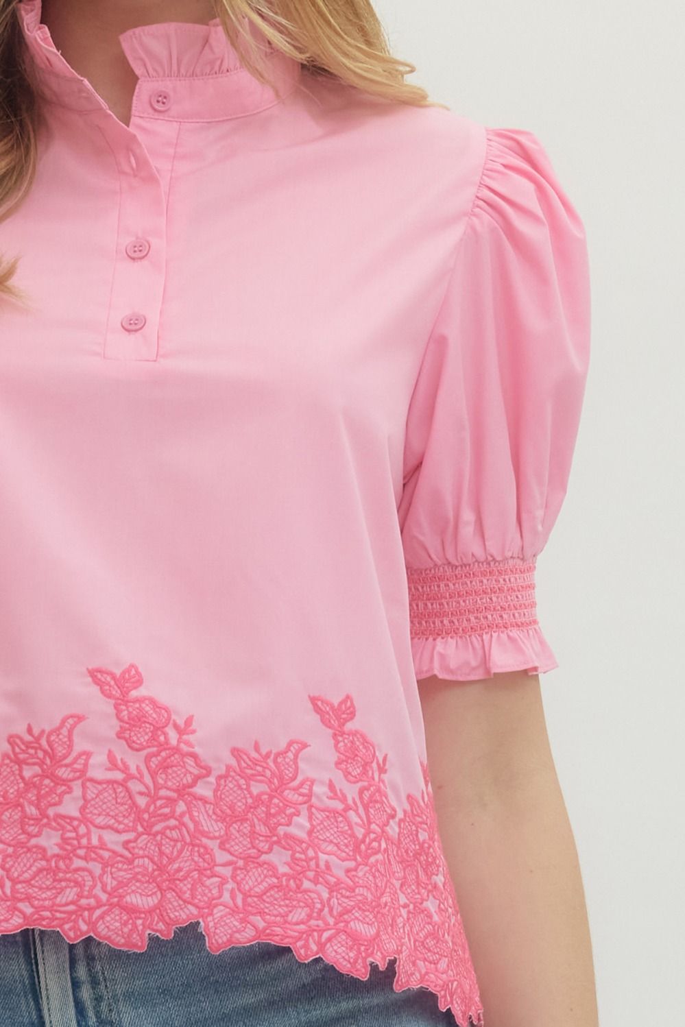 Pink blouse with lace detailing on a white background
