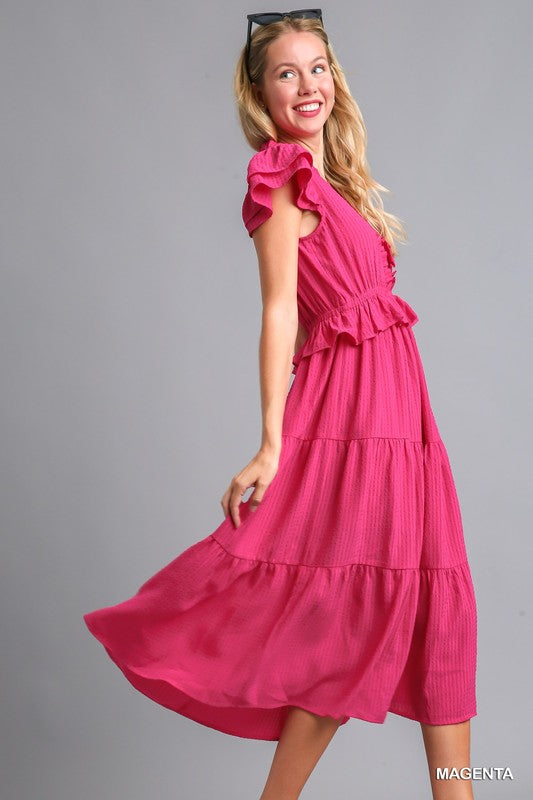 Side view of The Pink Posh Midi Dress, showing ruffled flutter sleeves and flowy tiered skirt movement.