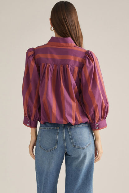 Back view of plum and rust striped blouse showing gathered back yoke and puff sleeves.
