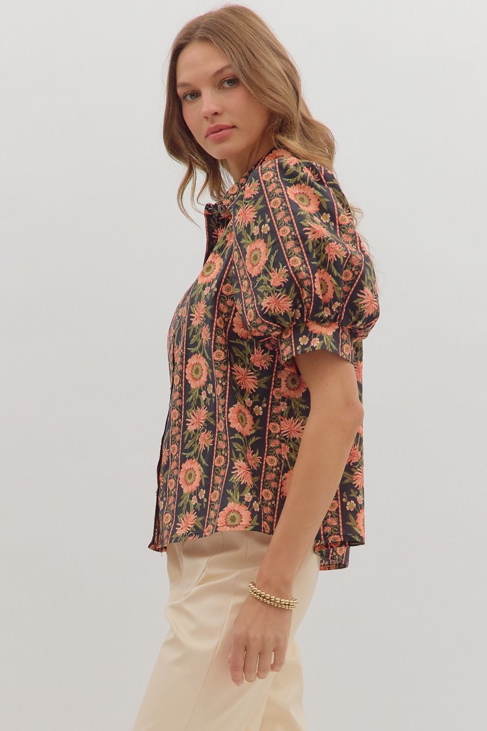 Stylish puff sleeve collared blouse with bold coral and green floral stripes on black fabric — boutique statement top
