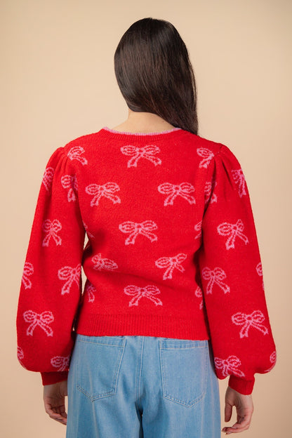 Back view of red holiday bow sweater with puff sleeves and pink bow pattern — cozy festive knit from Milo & Lily Boutique.
