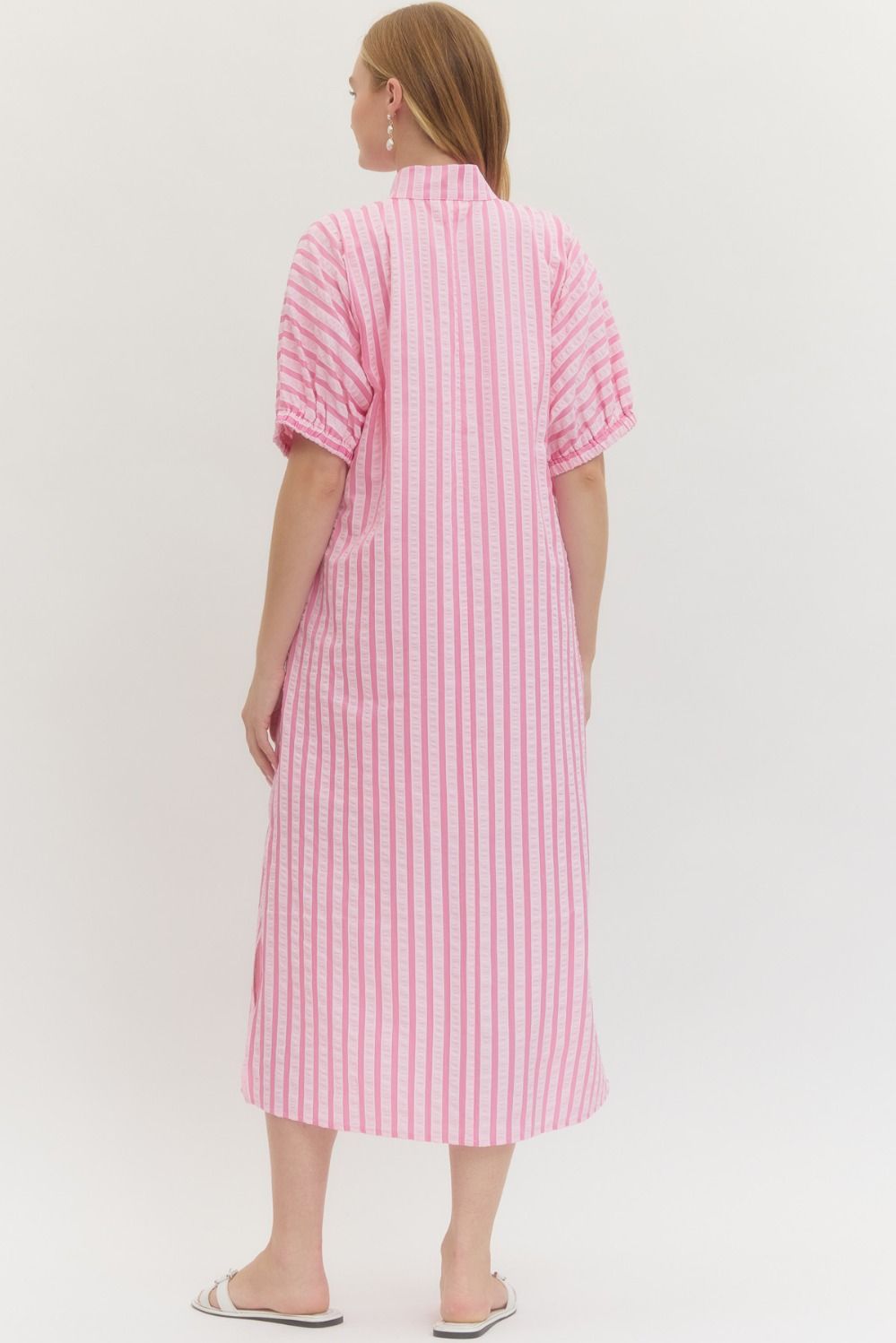 Woman wearing a pink and white striped dress on a white background